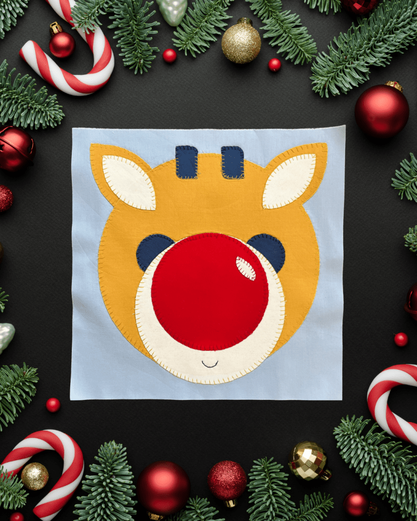 Applique Rudolph with an oversized nose and small antlers.