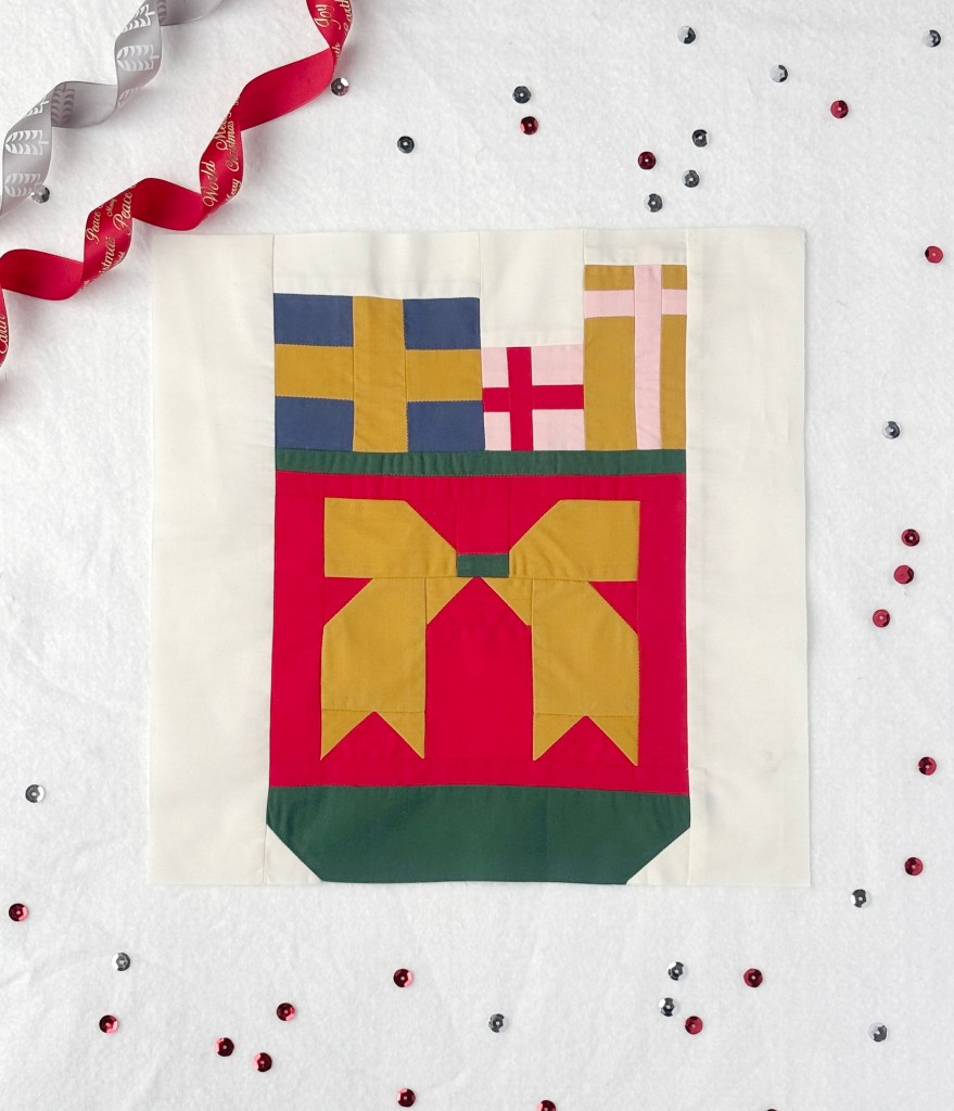 A red Santa sack with a gold bow, overflowing is packages.